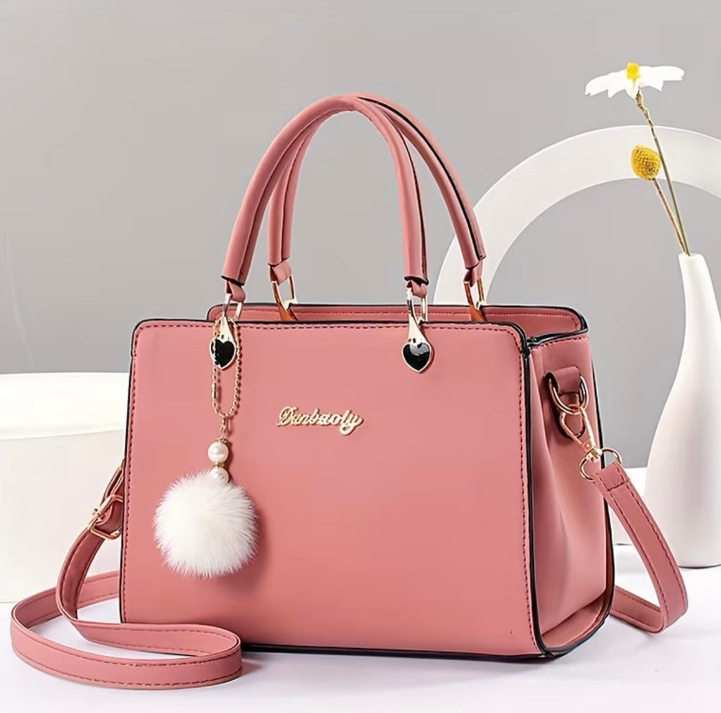 Fashionable handbag with decorative pompom
