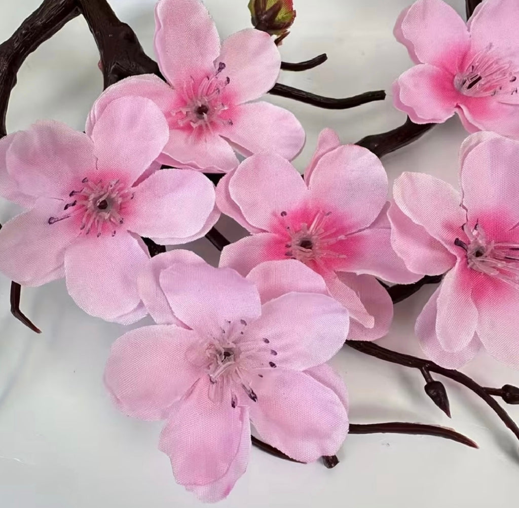 Un juego de plantas en maceta con flores de ciruelo artificiales