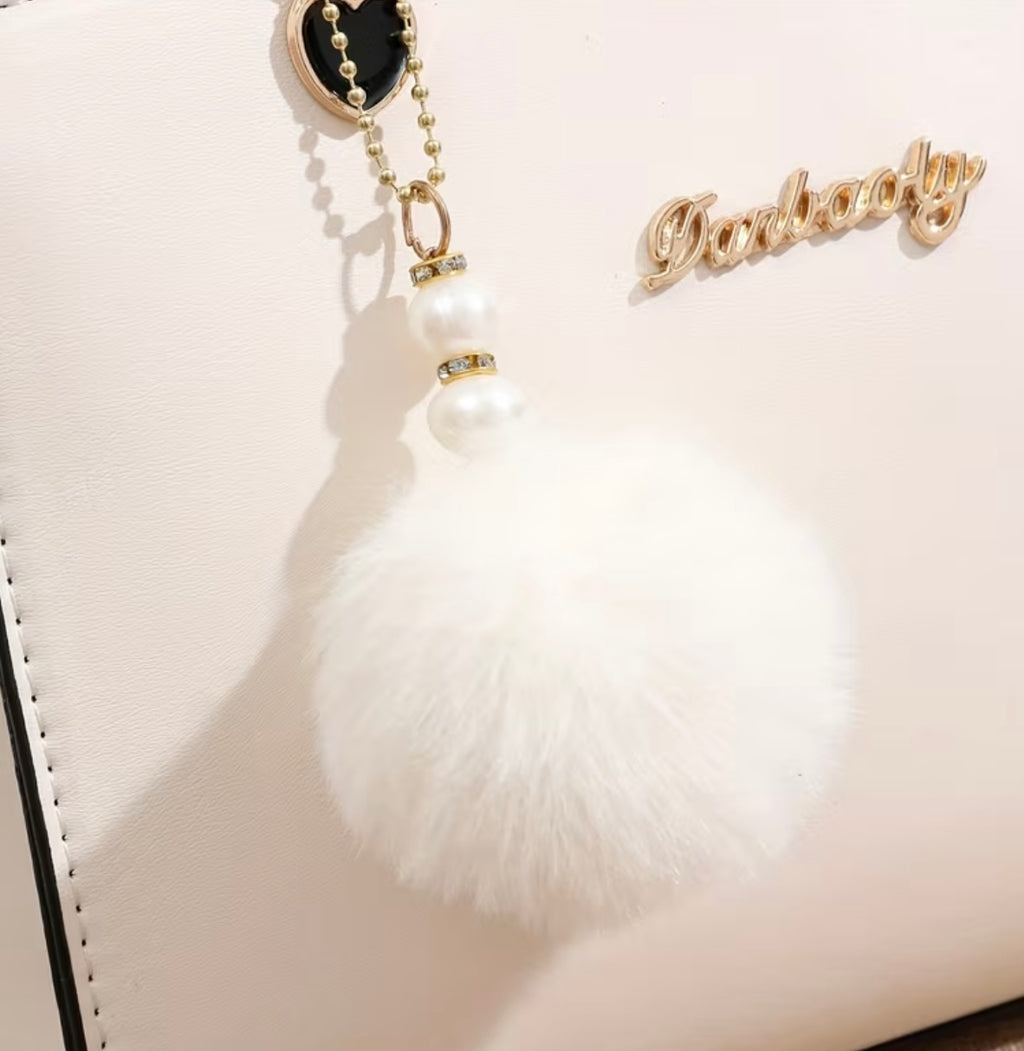 Fashionable handbag with decorative pompom
