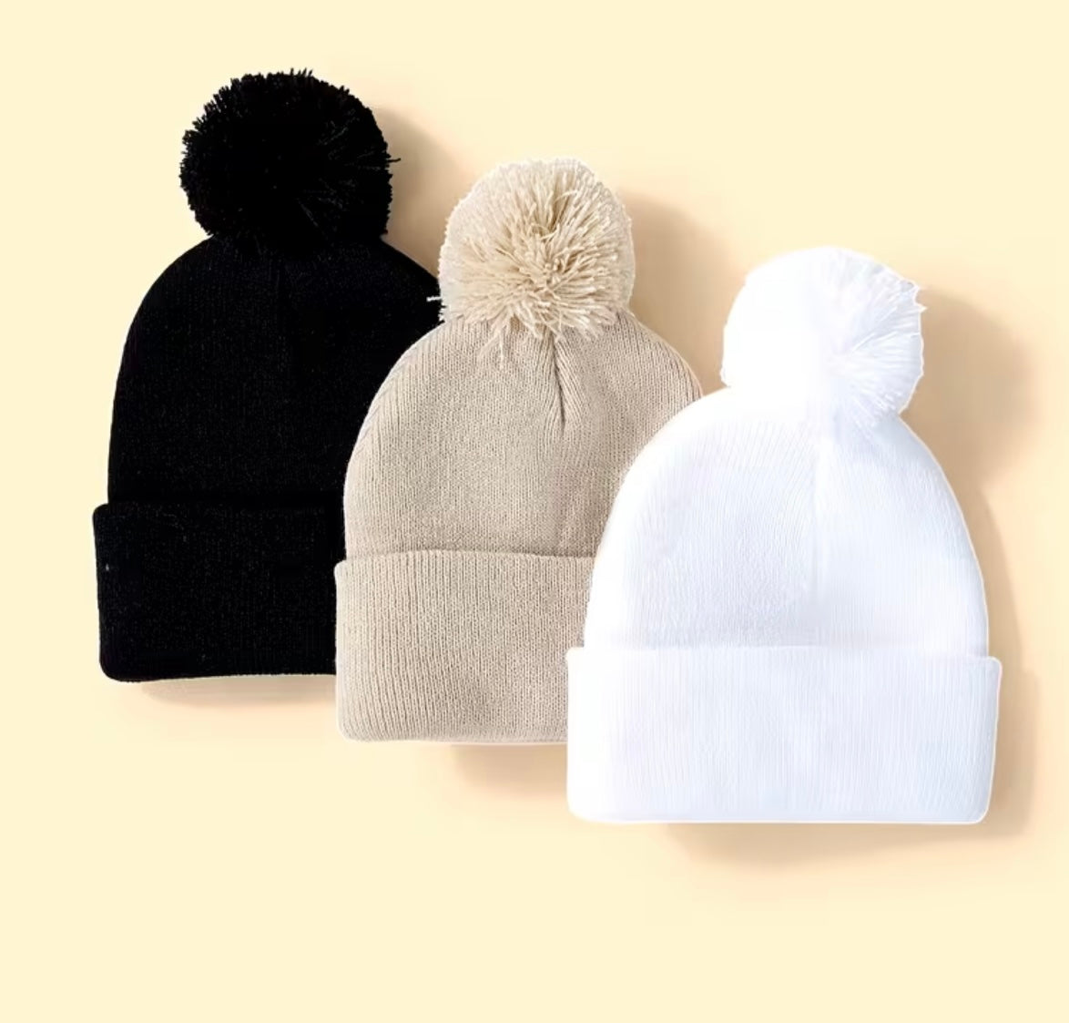 Set of three solid colour hats with women's pompoms