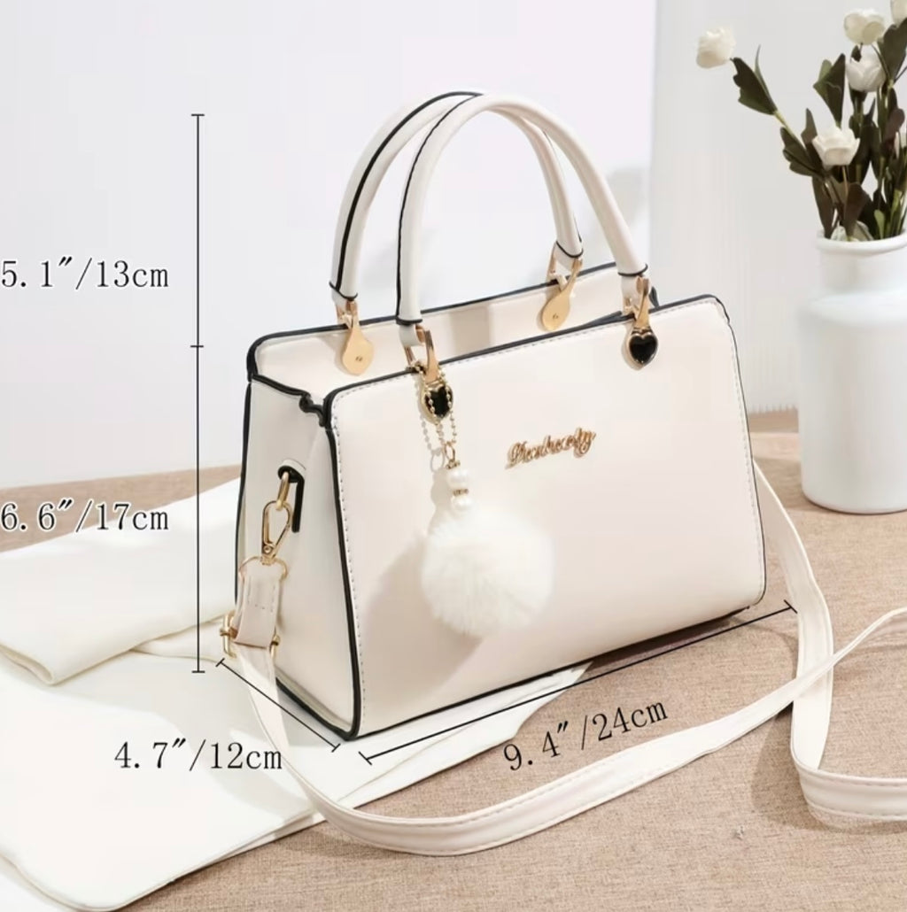 Fashionable handbag with decorative pompom