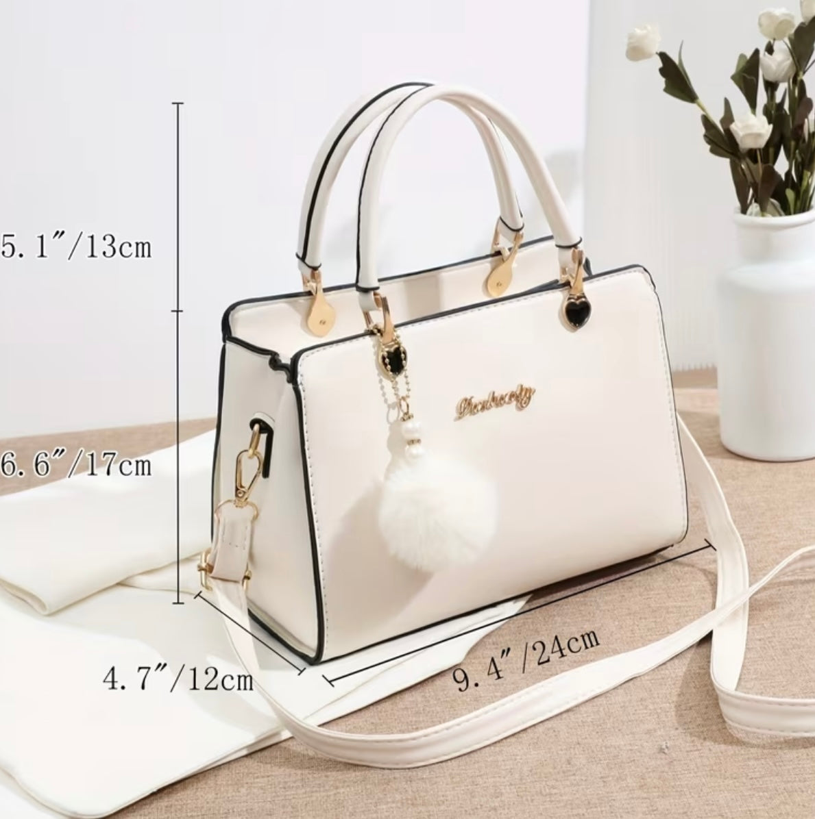 Fashionable handbag with decorative pompom